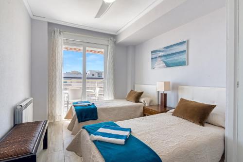 a bedroom with two beds and a window at Sol Mar Arzuaga in Jávea