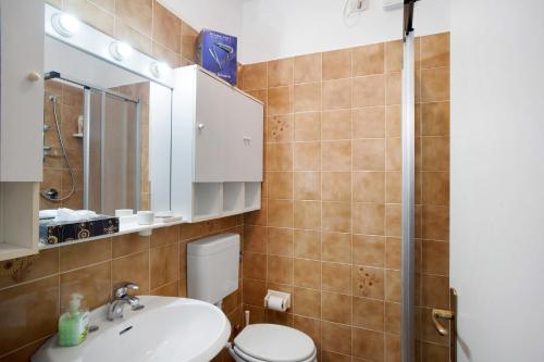 a bathroom with a toilet and a sink and a mirror at Albenga Le Morelle 2 in Albenga