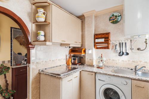 a kitchen with a washing machine and a sink at Apartamento Oliva in Barbate