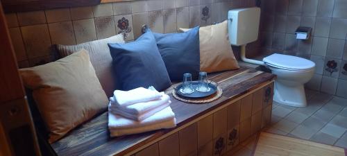 a bench in a bathroom with a toilet and pillows at Landhauswohnung Alte Mühle in Berlinghausen