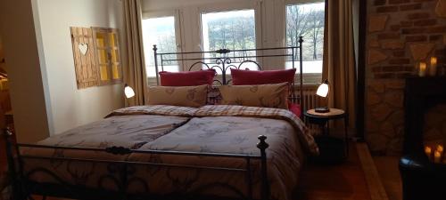 a bedroom with a bed with red pillows at Landhauswohnung Alte Mühle in Berlinghausen