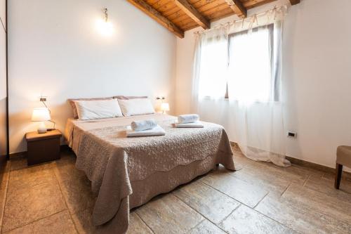 a bedroom with a bed and a large window at Villa Harmony in Quartu SantʼElena