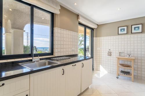 a kitchen with a sink and a large window at Villa Mara in El Campello