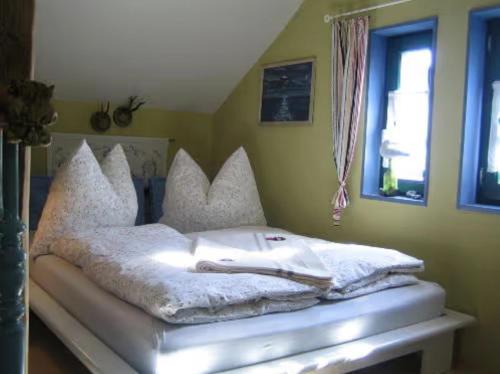 a bed with white sheets and pillows in a room at Villa Ilsebill in Ribnitz-Damgarten