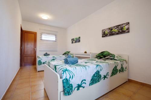 two beds in a room with white walls at Villa Dayely in Corralejo