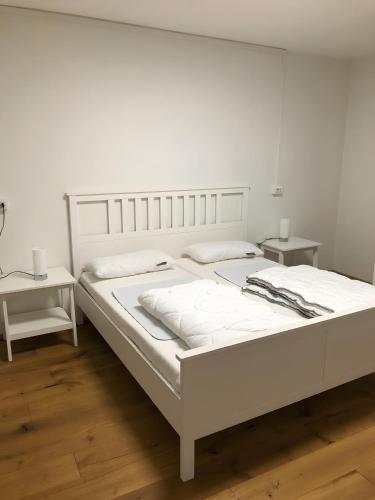 a white bed in a room with two tables at Villa Wetzel Domaso in Montemezzo