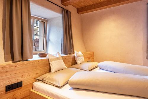 two beds in a room with a window at Egger an der Lahn - Apt Nonno in San Genesio Atesino