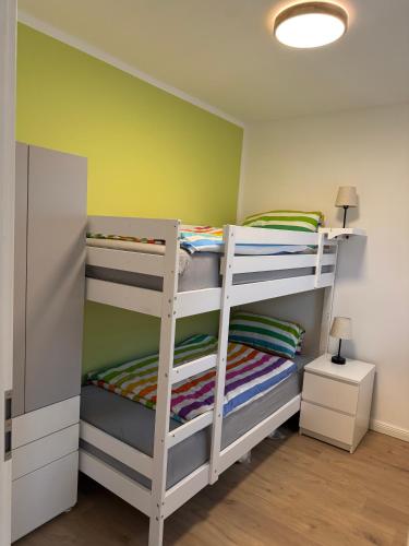 two bunk beds in a room with a green wall at Berg und Meer in WÃ¶lpinghausen