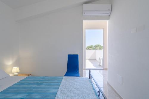 a bedroom with a bed and a blue chair at Littiricci in Marzamemi