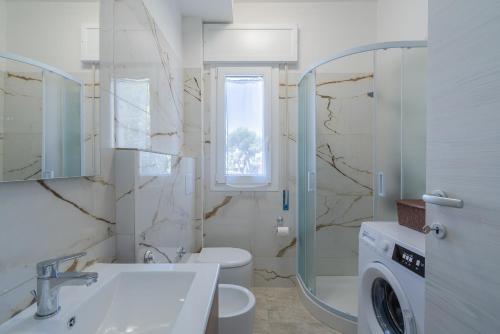 a bathroom with a sink and a washing machine at Littiricci in Marzamemi