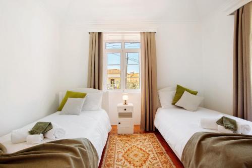 two twin beds in a room with a window at Mother's House in Calheta