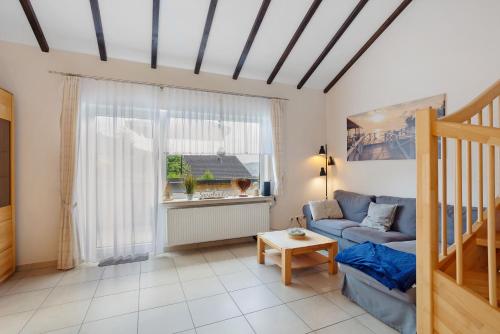 a living room with a blue couch and a window at Auszeit Sauerland in Olsberg