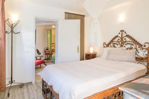 a bedroom with a large white bed and a red chair at Selão da Eira Velha in São Teotónio