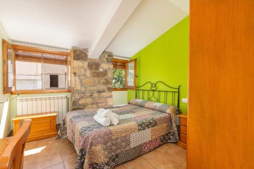 a bedroom with a bed in a room with green walls at Casa Ramona in Conques