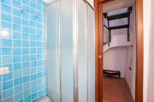a bathroom with blue tiled walls and a closet at Hora Hora in Orosei