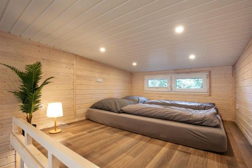 a bedroom with a bed in a wooden room at Tiny House Nr 1 in Schwielowsee