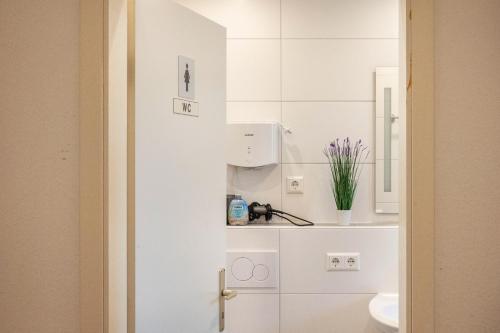 a white bathroom with a toilet and a sink at Ferienwohnung in Mecklenburg in Malchin