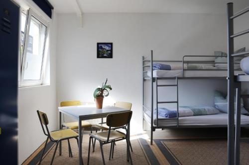 a room with a table and chairs and bunk beds at Ferienwohnung in Mecklenburg in Malchin