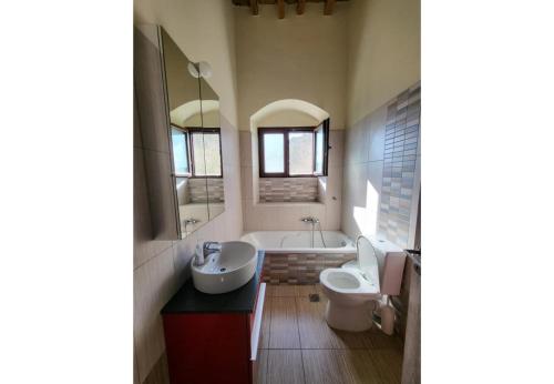 a bathroom with a tub and a sink and a toilet at Villa Two Pine Trees in Alinda