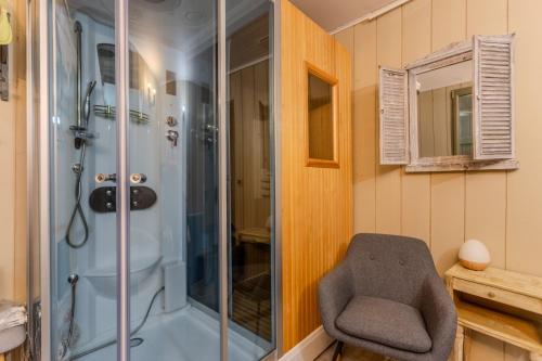 a bathroom with a shower and a chair in it at Maison Loustalet in Arzacq-Arraziguet