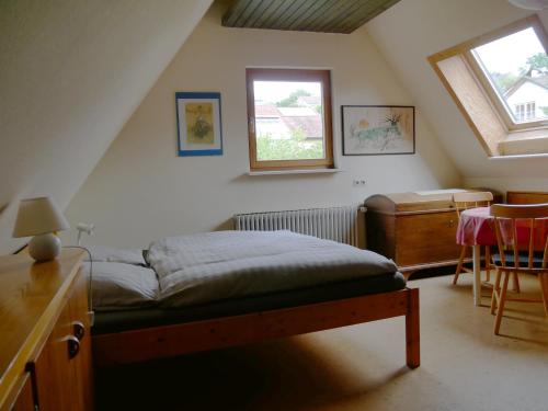 a bedroom with a bed and a table and a window at Ferienwohnung Lahr in Lahr