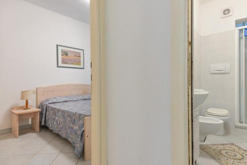 a bedroom with a bed and a bathroom with a toilet at Appartamenti Dolores in Campo nell'Elba