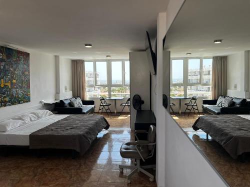a bedroom with two beds and a living room at Loft Molinos Corner in San Bartolomé