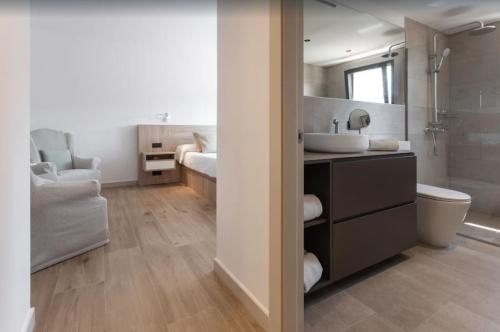 a bathroom with a sink and a toilet and a mirror at Villa Ona in Port de Soller