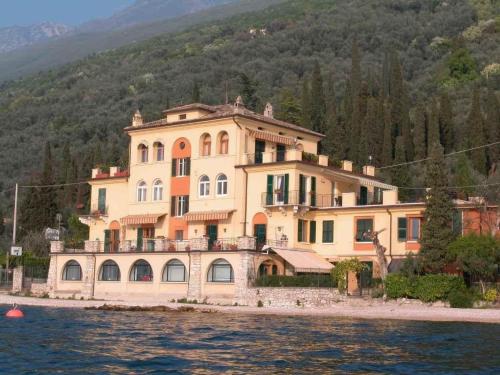 a large house on the shore of a body of water at Apartment CASA SPIAGGIA by Interhome in Castelletto di Brenzone