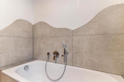 a bath tub with a shower head in a bathroom at Im Rosengarten 2 in Zell am Harmersbach
