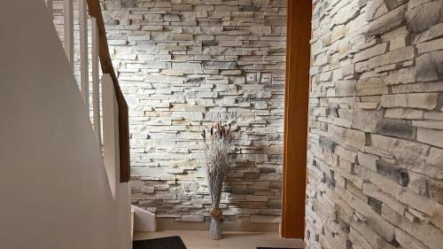 a room with a stone wall with a vase in a hallway at Reni's 4 Sterne Ferienwohnung in Leverkusen
