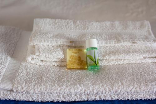 a bottle of soap and a book on a white towel at Casa do Avô - Alojamento Sortelha in Sortelha