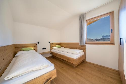 two beds in a room with a window at Sunnig Apartment Abendsonne in Vollan