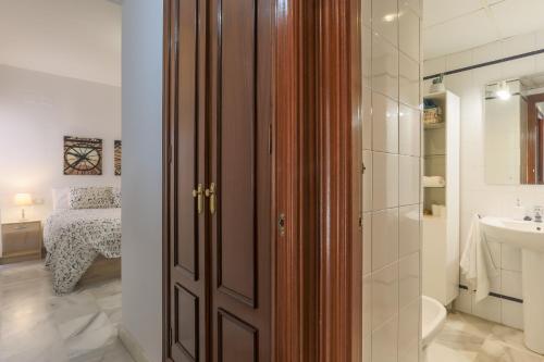 a bathroom with a wooden door and a sink at Fabled Parking in Seville