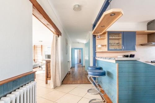 a kitchen with blue cabinets and a blue stool at Logement vue mer à 50m de plage in Barbâtre