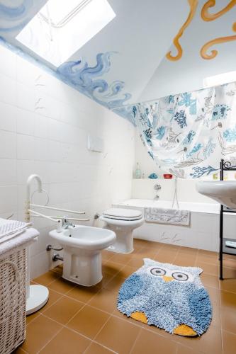 a bathroom with a toilet sink and an owl rug at Suite Al Pian Apartment in I Gugi