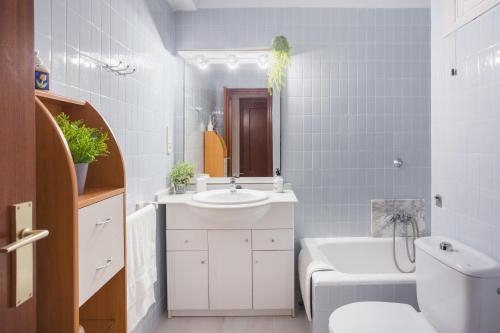 a bathroom with a sink and a toilet and a tub at Flamingo in Tavernes de Valldigna