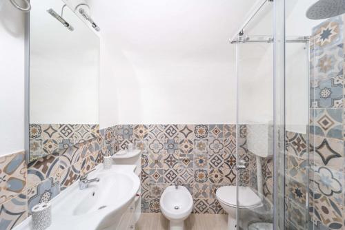 a bathroom with a toilet and a sink and a shower at Casa Gilbert 101 in Alghero