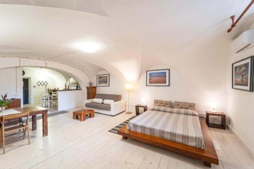 a bedroom with a bed and a living room at Casa Gilbert 101 in Alghero