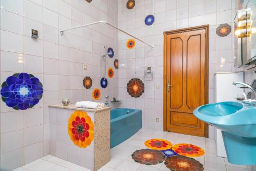 a bathroom with a sink and a blue tub at Il Comandante in Piedimonte Etneo