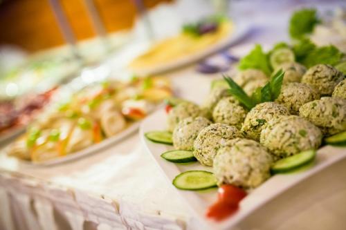 a table with plates of food on a table at Hotel ***NAT Świnoujście in Świnoujście