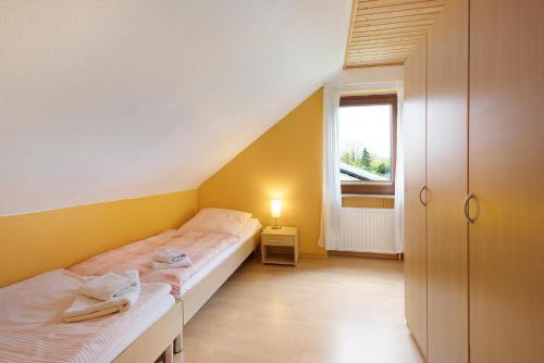 a small bedroom with two beds and a window at Urlaub Ostholstein in Stockelsdorf