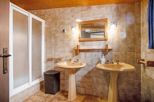 a bathroom with two sinks and a mirror at Moinho das Esteveiras in A dos Cunhados