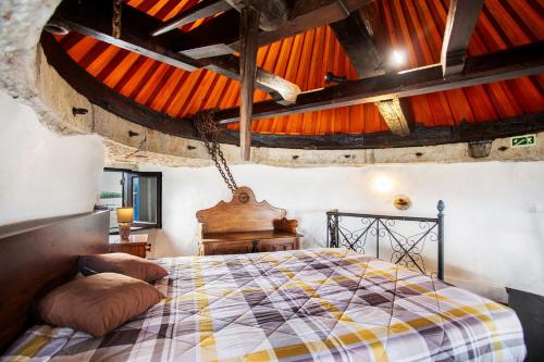 a bedroom with a bed in a room with wooden ceilings at Moinho das Esteveiras in A dos Cunhados