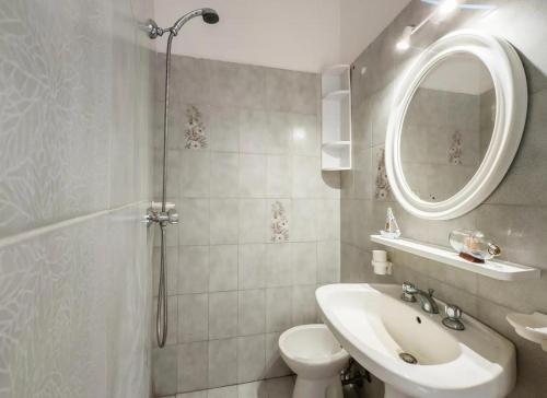 a bathroom with a sink and a toilet and a mirror at Sabbia e Sorrisi Sea View in Porto Cesareo