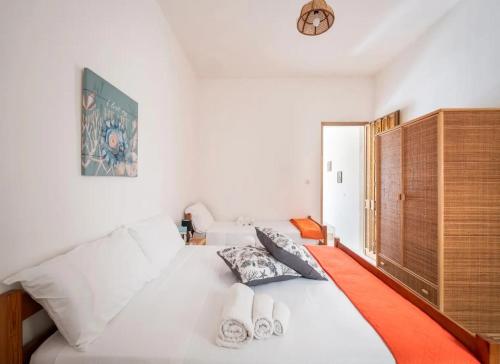 a bedroom with a white bed and a wooden cabinet at Sabbia e Sorrisi Sea View in Porto Cesareo