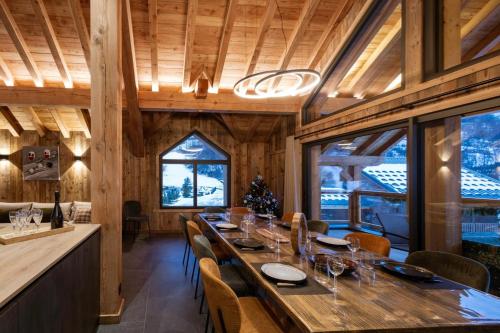 a dining room with a long table and chairs at Chalet-Spa Le Cervin in Valloire