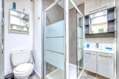 a bathroom with a toilet and a glass shower at Chalet dans résidence piétonne in Hourtin