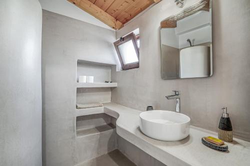 a white bathroom with a sink and a mirror at Angel’s studio in Potamós