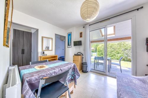 a room with a table and a balcony at Chalet dans résidence piétonne in Hourtin